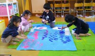 室内で5歳児たちがこいのぼりを描いている様子