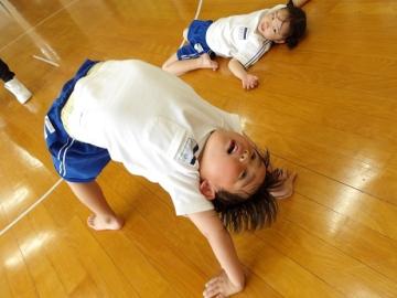 室内で幼児がブリッジをする姿