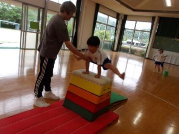 室内で幼児が跳び箱を跳ぶ姿