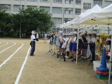 吹奏楽部の生徒が指揮者の前で開会式入場行進の演奏している様子