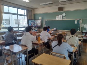教室で机に向かって座る数人が前方の黒板とテレビ画面を見ている様子