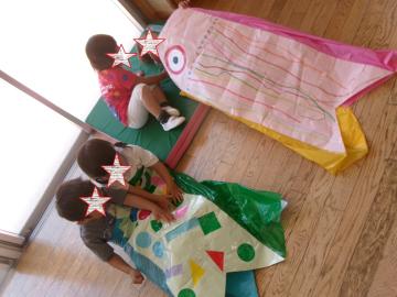 3歳児がこいのぼりで友達と一緒に遊んでいるところ