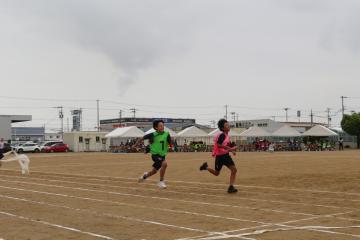 男子リレーでバトンをもって走る生徒たち