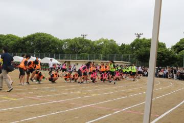 3年学年演技　運動場にクラスごとで固まってしゃがんでいる生徒たち