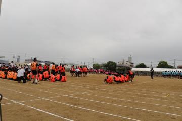 生徒会演技　運動場でクラスごとに固まって座ったり走ったりする生徒たち