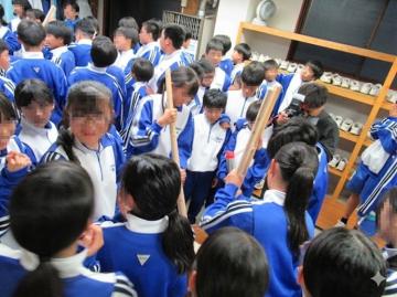 青いジャージを着た多数の学生が餅つきをしている様子