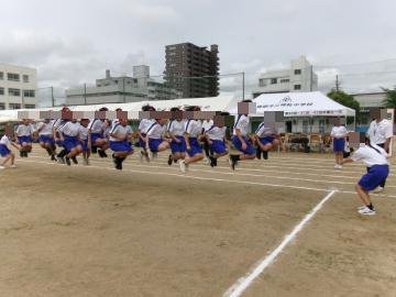 運動場で生徒たち長縄跳びを一斉に跳んでいます。