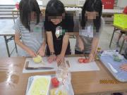 児童3人が一緒にピザの生地を捏ねている様子