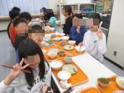 テーブルで複数の人が向かい合って食事をしている場面