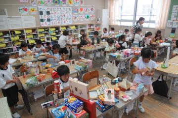 1年生が箱や缶を組み合わせて作品を作っている様子