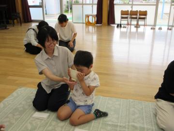 男の子が、お茶碗をお母さんに支えられながらお抹茶を飲んでいる様子