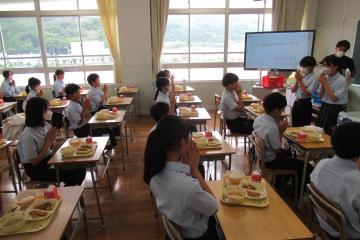 配膳が終わりいただきますの手を合わせている7年生の様子