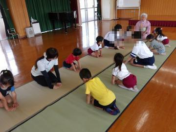 室内で茶道教室で5歳児が先生におじきの仕方を教えてもらっている様子
