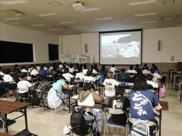 エコパークあぼしの大きな講義室で環境に関する映像を視聴している4年生の様子