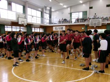 体育館内での選手入場で、男子卓球と書かれたプラカードを持った参加者の様子です。