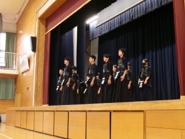 体育館の壇上で、剣道部の生徒たちが決意表明をしている様子