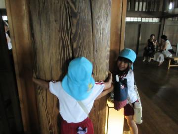 姫路城の柱の太さを手を広げて測る子供たち