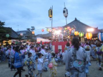 地域の人たちがやぐらを囲み盆踊りを踊る様子