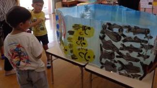室内で制作したミニ水族館の魚を見る園児たちの様子