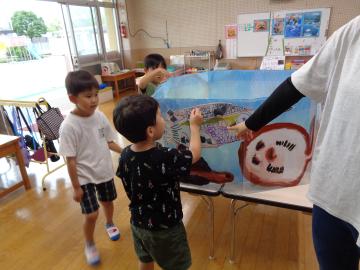 室内で制作したミニ水族館のアリゲーターを見る園児たちの様子