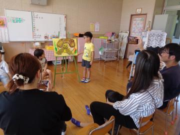室内でイラストを用いてリクガメについて話す園児の様子