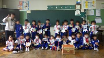 1年生が教室の黒板前で集合写真を撮っている様子
