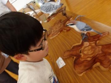 幼児が木彫りの野鳥を観察する様子