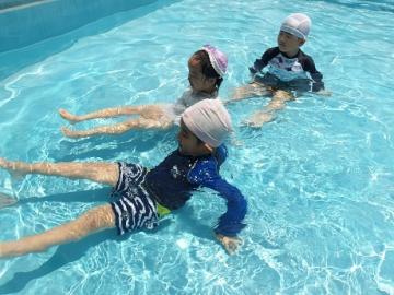 幼児がプールの中で気持ち良さそうに遊ぶ様子