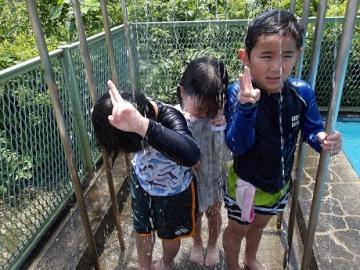 幼児がプールのシャワーにかかっている様子