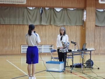 体育館で生徒が講師の前に立ち、お礼を伝えている様子