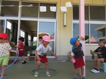 園内で、フープを使ってダンスごっこをしている園児たちの様子