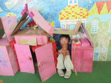 室内で、段ボールで作ったピーチ城でアイスを食べている園児の様子