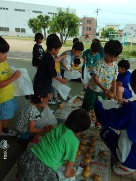 幼児が家へ持って帰るジャガイモを選んでいる様子