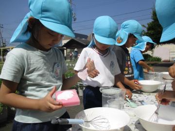 幼児が泡遊びで、スポンジに泡を塗って、ケーキを作っている様子。