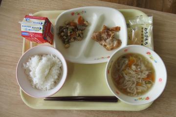 机上のトレーの上に置かれた後期課程の七夕献立の給食の写真。ご飯やそうめん汁などが配膳されています。
