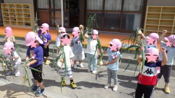 収穫したタマネギに喜んでいる幼児