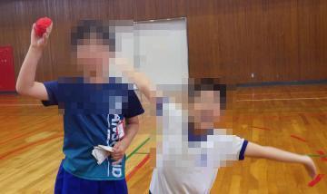 体育館で、宝をみつけてポーズする児童たちの様子