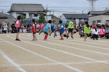 トラックで4年生から6年生の希望者が地区別対抗リレーを行う様子