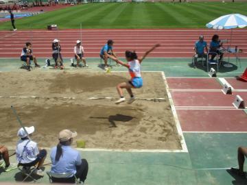 走幅跳で大きなジャンプする陸上選手の様子