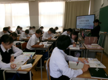 教室で席に座った生徒達がノートに板書する授業風景