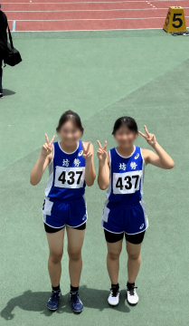 競技場内のトラック上で、陸上競技部の選手が100メートル予選を走り終えた直後の様子です。
