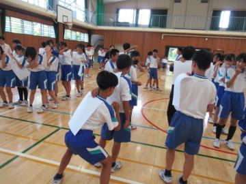体育館内で、生徒たちがお互いのいいところを書きあっている様子
