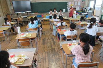 3年生が日番の指示で手を合わせて「いただきます」をしている様子