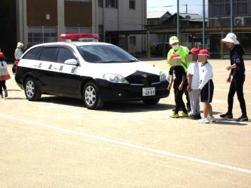 児童が駐車している車をよけて通る様子。