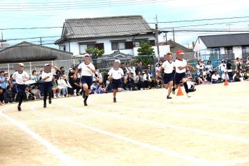 校庭のトラック上を髙学年が100メートル走で走っている様子