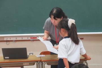1年生が担任の先生から通知表の説明を受けている様子