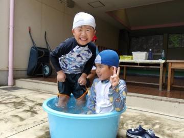 幼児2人がタライの中にお風呂のように入る様子