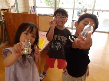 幼児が星の世界の砂をもって写真を撮る様子