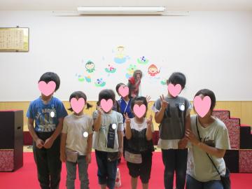 遊戯室で園児たちと猿のアイちゃんが並んでポーズをしている
