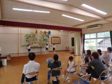 遊戯室内で、七夕のつどいでダンスをしている園児たちと観覧する保護者たちの様子